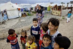 A group of young children and a mother posing in the refugee camp of Qushtapa, near Erbil. Around 7,000 refugees, mostly Syrian have been living there since 2012. © Tom Verbruggen