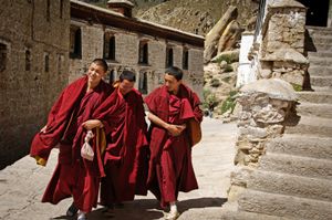 These monks are on their way to attend noontime devotions in the main temple at Drepung Monastery. Drepung sits high on a mountainside outside of Lhasa, Tibet. It was once the largest monastery in the world with 10,000 monks in residence. Today, about 700 live there. Photographed on 29 June 2005 © Forest McMullin