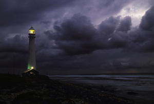 Lights into darkness / The light from the Slangkop lighthouse in a storm over the Atlantic Ocean, South Africa