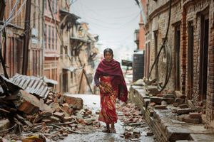 A woman walks through the rubble of homes destroyed during the 2015 Nepal earthquake.
