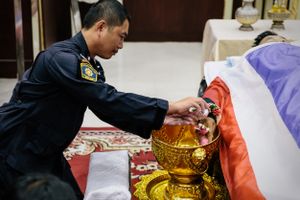 Following violent clashes between police and anti-government protesters, four people died. The funeral of a policeman took place the next day, during which family, friends and colleagues observed traditional bathing rites, pouring water onto the deceased's hand.