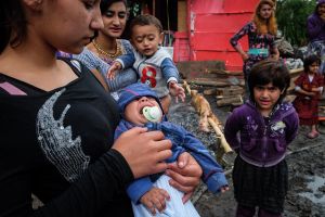The mother tries to calm the baby during the celebration of Djurdjevdan in a Roma settlement near Belgrade 2017.