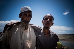 The Rohingya Refugee Crisis. Two old exhausted men arrive at the shore of Bangladesh, after fleing Burma on boat. They had to the nearest camp.