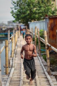 Boy running across a bridge