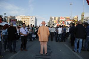 A man with orange suit stands on flooded by demonstrators Taksim Square during anti-government protest in Istanbul, Turkey on Saturday, June 8 2013.