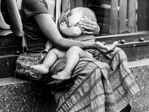 A young mother begs as she breast feeds her apparently healthy infant, Kyiv's most fashionable and park-like street.
