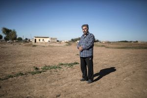 Amar a Syrian Kurdish from Kobani stands in front of a house where he lives temporarily with his family in the town of Suruc near the Turkey-Syria border on November 5, 2014.