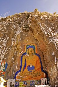 This rock carving of the Medecine Buddha is near Nyethang, Tibet. It's about 40 feet high and is surrounded by white prayer scarves left by pilgrims. Photographed on 30 June 2005. © Forest McMullin