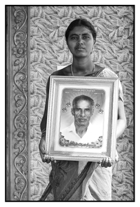 Vasanthi with portrait of her father, a debt-stressed farmer who “died of a heart attack.” Tamil Nadu, India.