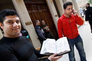 A man shows an old Coptic bible                 The Coptic World © Bert Spiertz