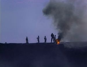 In the hills around Cizre, south-east Turkey. March 20, 2003. Newroz. Kurdish children watch as a policeman extinguishes a burning tyre.