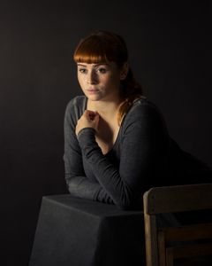 Redhead girl leaning on pedestal