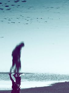 À travers le reflet de l'eau, une silhou­ette se dessine
