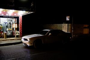 Two youngsters in a Ford Mustang wait for their friend, buying licquor in a nightshop in Ankawa, the Christian part of Erbil. © Tom Verbruggen