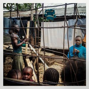 A family outside their home with clothes hanging on a washing line. The Kibera slum is the largest slum in Nairobi with around half a million inhabitants.