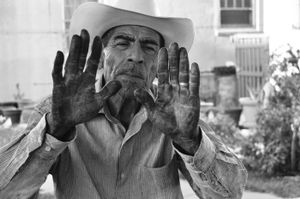 Vicente showing what his hands look like at the end of a day picking chiles. © Joseph Sorrentino
