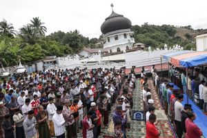 Survivors perform Friday mass prayer outside a collapsed Jami Quba Mosque following the earthquake in Pidie Jaya, Aceh province, on December 9, 2016.