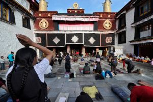 Pilgrims and local residents pray in the courtyard in front of the main entrance to the Jokhang, the temple and monastery at the heart of Lhasa, and the focus of the chak pilgrims. © Michael Freeman