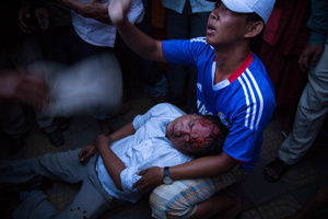 A man tries to stop a mob from attacking a man they thought was Vietnamese at Stung Meanchey District in Phnom Penh.