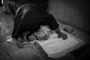© Christian Werner - Iraq, Basra, 24 April 2012 – In a small room at the children’s graveyard in Basrah the bodies of dead children receive a ritual washing before they are buried. An elderly woman mourns and prays for her dead child.