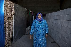 A Kurdish woman, Samse, who lost her husband and son during the conflict in Kobani, poses for a photo inside a factory used as refugee camp, known as Suphi Nejat Agirnasli in the town of Suruc, Sanliurfa province, Turkey on November 9, 2014.