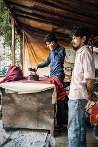 Launderer in the Mumbai street, in his hands two centuries of technology.