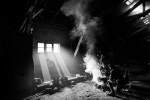 Men gather around a fire at the barracks ,during the meal. Belgrade, Serbia.