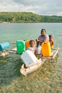 Rita Vano, 32 years with her sons Kaloris, 6 years and Athy 4 years, Sunae Village, Moso Island. Collecting water from Efate Island.