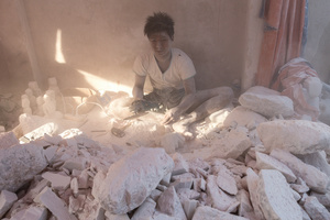 Child labourer sorts rocks at workshop in Mandalay, Myanmar.
