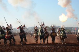Musket blasts and smoke as riders pull to a halt. Oulad Haddou, Bouskoura, Morocco