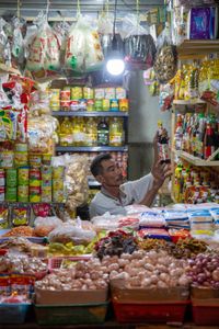 The shopkeeper carefully organizes the products on the shelves