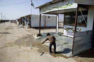 A boy cleaning the front entrance of his family's shop in Zaatari's main road.© Tom Verbruggen