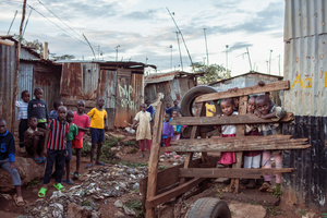 Kijiji slum, Nairobi, KENYA, 07.11.2013: A group of children stand next to a sewage channel built by Tegemeo (“Depending on us”) youth group. The group of young adults dug sewage drains, built bridges to cross those to minimize disease and infection risk, initiated garbage collection, a recycling centre, and organized access to fresh water.