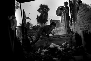 © Christian Werner - Iraq, Baghdad, 18 April 2012 – On the cemetery in Baghdad, three children clean a grave with water from a battered canister.