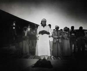 Negev Desert, Israel (2005). Unrecognized desert village. Dusk. Men praying.