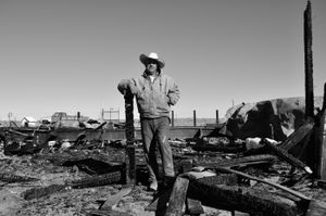 Jesús standing among the ashes of his trailer, which burned down two days earlier. © Joseph Sorrentino