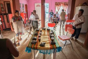 After the praying is done and the ancestors have had their part of the offerings everybody sits down to eat,