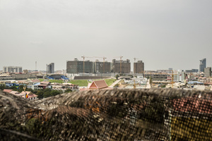 View across Phnom Penh to one of the largest construction sites in the capital, Olympia City. In 2014 a metal bar fell from the 12th storey of the site hitting a 42 year old woman as she rode past on her motorbike killing her instantly.