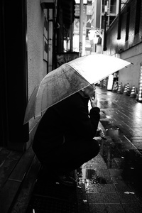 A man smoke under the rain in Shinjuku