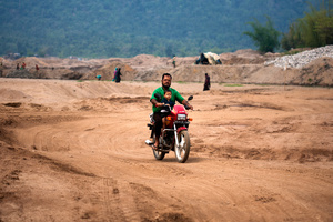 A local man rides a motor bike near the stone quarry