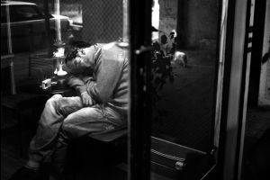 A man sleeping inside a cafe bar in the city center. Athens, Greece  Enri Canaj