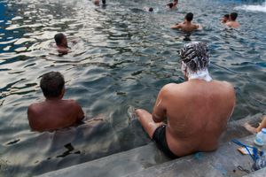 Man is taking a bath and using a shampoo in the pool