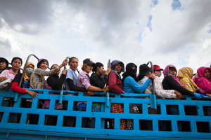 Garment factory workers pile up in trucks to make their daily journey to and from work. Kampong Speu, Cambodia.