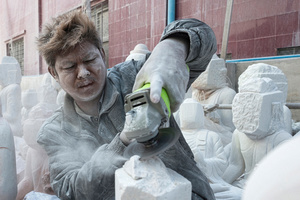 Worker cutting stone at workshop in Mandalay.