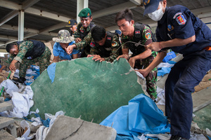 Cambodian armed forces search through the rubble for survivors after a building collapsed at Wing Star shoe factory killing two.