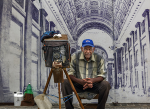 Photographer with old camera ( Polaroid ) waits for clients in front of the Capitolio.