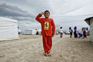 A young boy in a trainer with Ferrari logo in the refugee camp of Qushtapa, near Erbil. Around 7,000 refugees, mostly Syrian have been living there since 2012. © Tom Verbruggen
