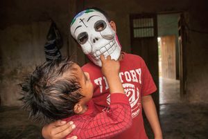 Kids play with a Day-of-the-Dead mask they purchased in a store.