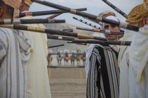 A rifleman peers out amongst the group enacting a traditional warriors gun dance. Tissa, Morocco