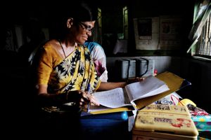 A vaccine Monitor checks a data for vaccine distrbution in Rafiq Nagar, Mumbai, Maharashtra